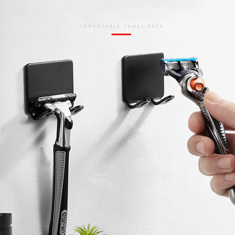Une main tient un porte-rasoir multifonction fixé au mur.