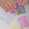 Hands displaying multi-color 3D hibiscus flower nail decals on fingernails.
