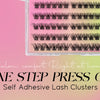 A clear plastic container holds various clusters of black false eyelashes for DIY lash extensions.