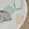 A collection of portable makeup mirrors in mint green and beige tones placed on a white surface.