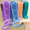 A collection of silicone body scrubbers in various colors hanging on a rack.