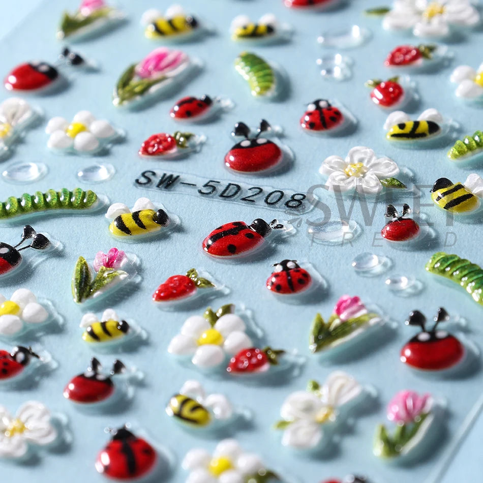 A collection of embossed floral nail art stickers featuring spring designs like bees, flowers, and leaves on a light blue bac