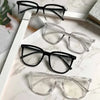 Colección de gafas cuadradas vintage anti-luz azul en marcos negros y transparentes sobre una superficie de mármol blanco.