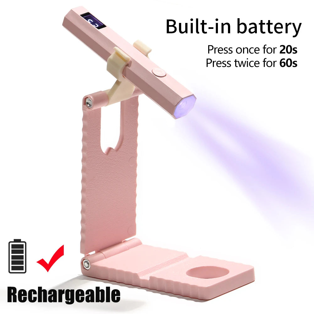 A pink portable rechargeable UV LED nail dryer device shown with its battery and charging port.