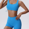 Una mujer modela un conjunto deportivo de yoga y gimnasio azul brillante, transpirable y de secado rápido, con top y shorts a