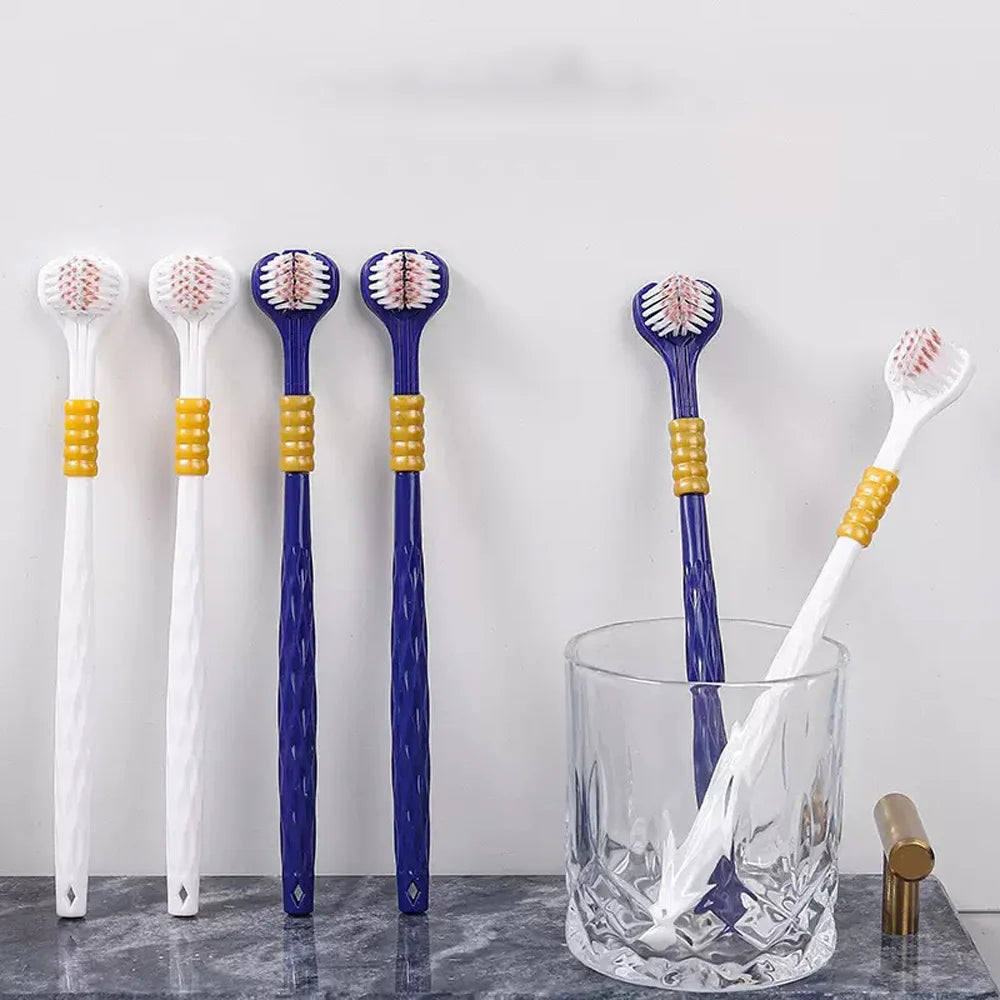 Ein Set von vier blauen und weißen weichen Borstenzahnbürsten auf einer Glas- und Marmoroberfläche.