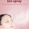 A woman is applying an ion spray facial mist to her face, with a cloud of mist visible.
