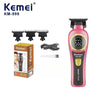 A pink Kemel KM-999 cordless electric hair clipper with a black battery and charging cable.