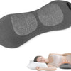Grauer Lenden-Massager neben einer Person, die bei Rückenschmerzen lindern liegt.