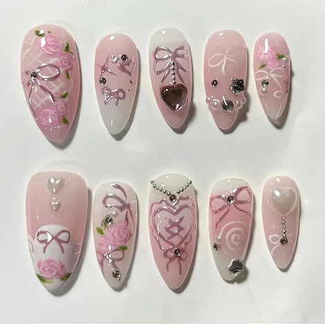 A set of 24 pink heart pearl press-on fake nails featuring various floral and decorative designs.