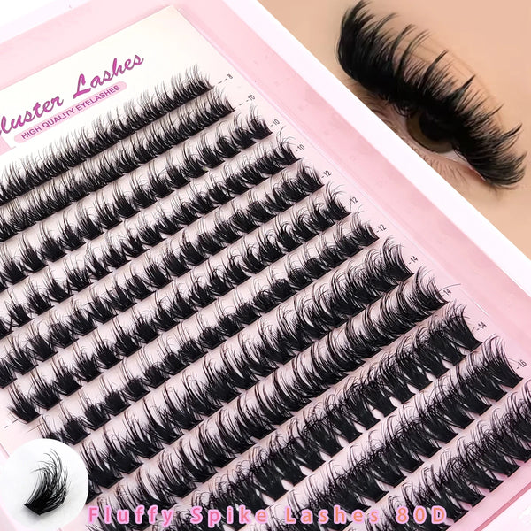A close-up of a set of black fluffy spike lashes for eyes, displayed on pink packaging.