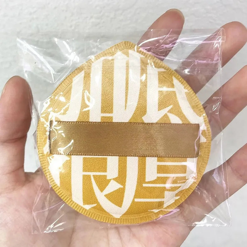 A yellow makeup puff set with a storage box is shown inside clear plastic packaging.