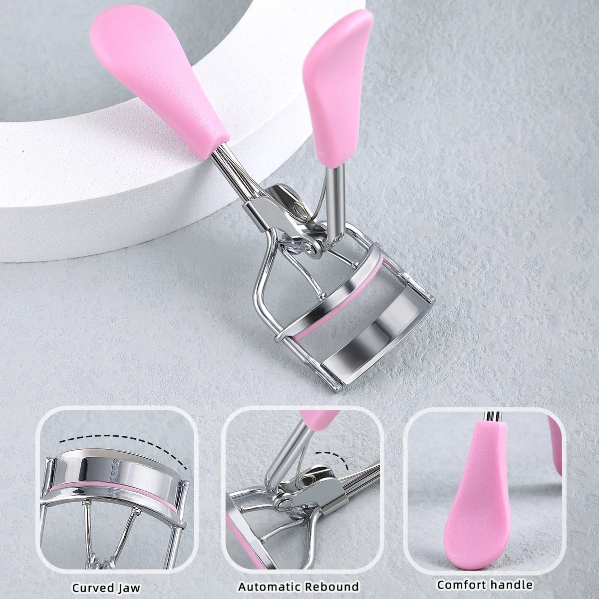 A set of professional stainless steel eyelash curlers with pink handles, showing the curved jaw, automatic rebound, and comfo