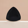 A black triangular cosmetic foundation puff brush resting on a light surface.