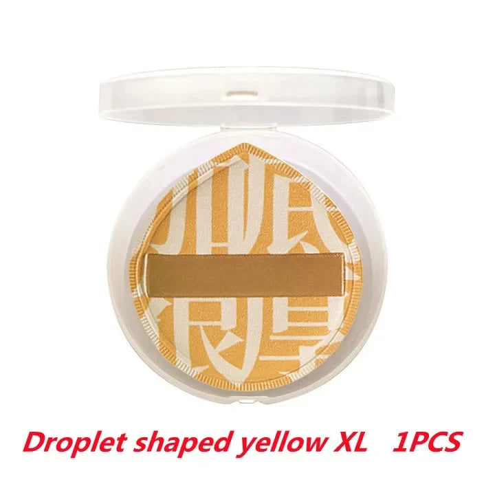 A round makeup sponge puff in a yellow color with a droplet shape, packaged in a clear container.