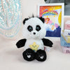 A white and black classic Care Bears plush stuffed animal doll sitting next to a framed picture.
