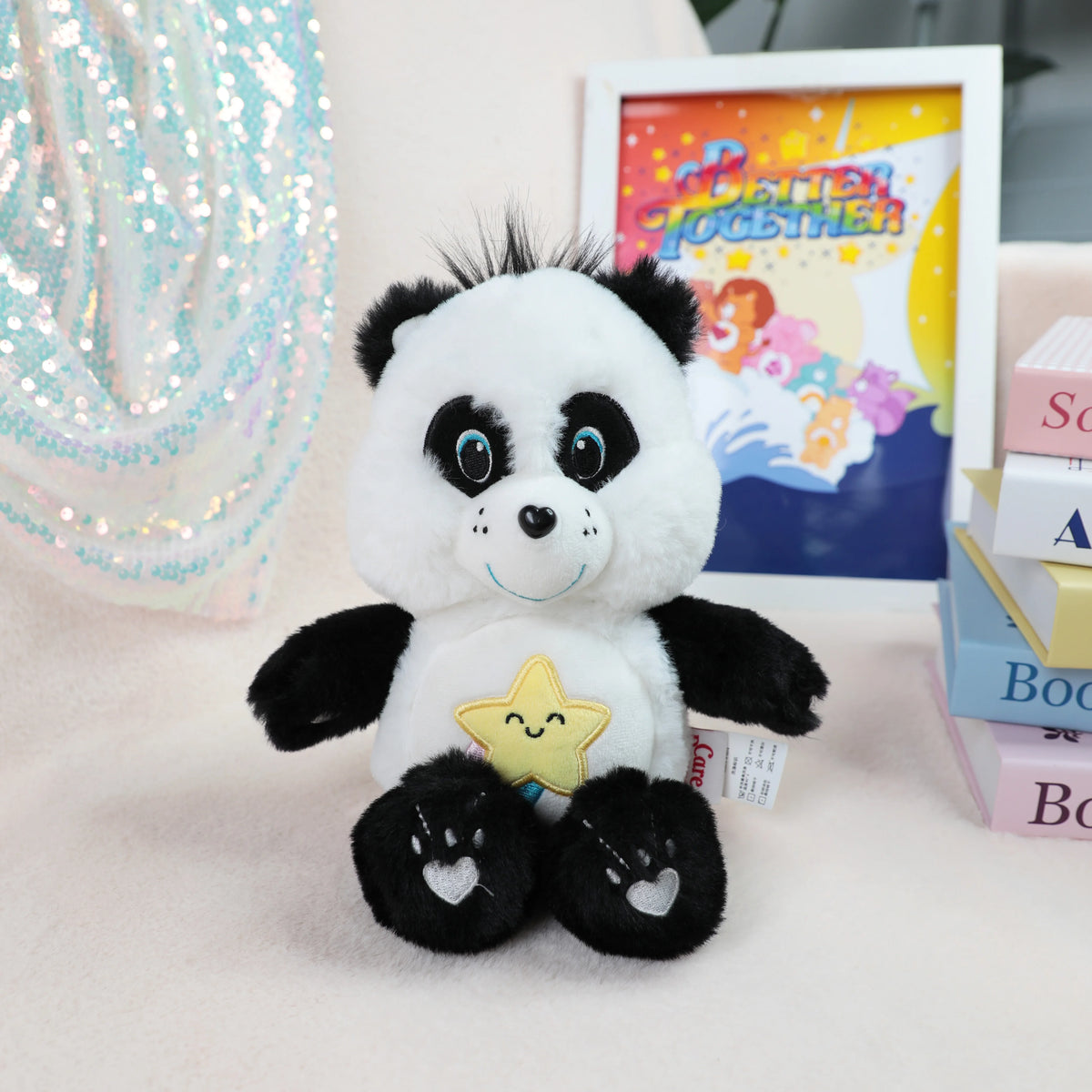 A white and black classic Care Bears plush stuffed animal doll sitting next to a framed picture.