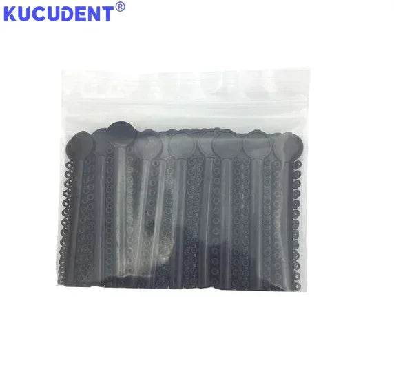 A clear plastic bag containing multiple black orthodontic elastic ligature ties for braces.