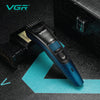 A close-up view of a blue VGR electric beard and hair trimmer resting on a dark surface.