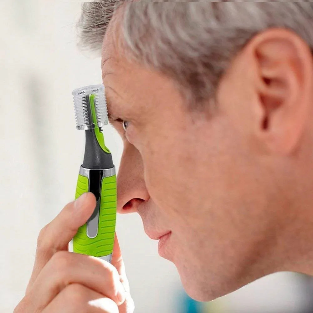 A person is using a green and silver 2-in-1 rechargeable nose and ear hair trimmer.