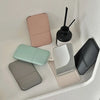 A collection of portable makeup mirrors in various pastel and neutral tones, including pink, mint green, gray, and black.