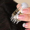 Une main tient un applicateur en verre à plusieurs pointes, utilisé pour appliquer des huiles essentielles ou des traitements