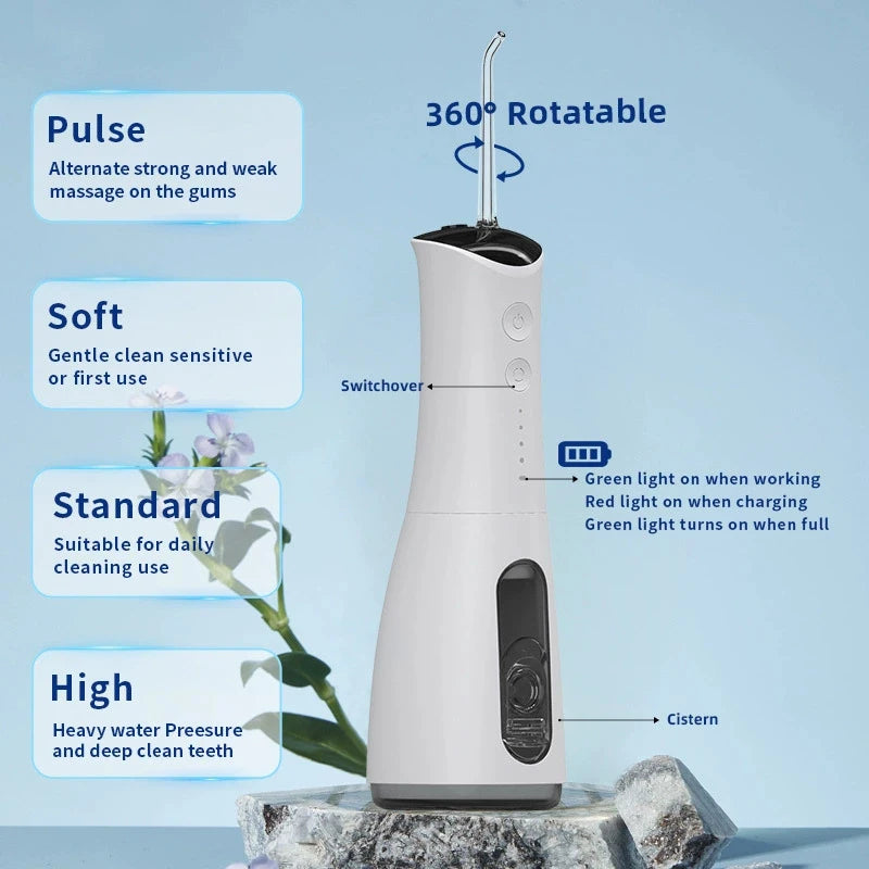 A white portable dental water flosser with a detachable tip, shown next to a plant.