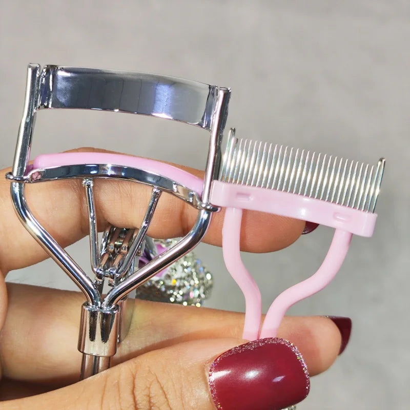 A hand holds a professional eyelash curler set with silver metal and pink plastic components.