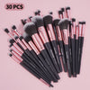 A collection of 30 professional makeup brushes in various shades and sizes displayed on a pink background.