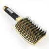 A gold-colored nylon bristle detangling comb with a black handle and white accent.