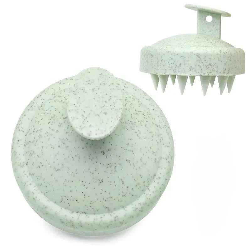 A light green silicone scalp massage and body brush with a flat head and multiple prongs.