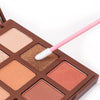 A brown makeup palette with a pink brush applicator and various eyeshadow shades.