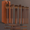 A set of 14 professional makeup brushes and sponges in a brown leather case and various wood-colored handles.