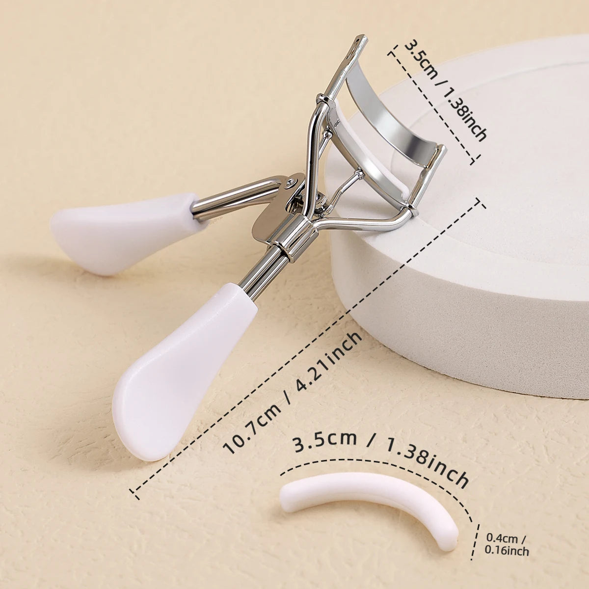 A professional stainless steel eyelash curler set with white handles and various sized curlers shown on a light background.