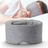 Un masque de sommeil en coton gris et confortable porté par une personne, avec un autre masque à proximité.