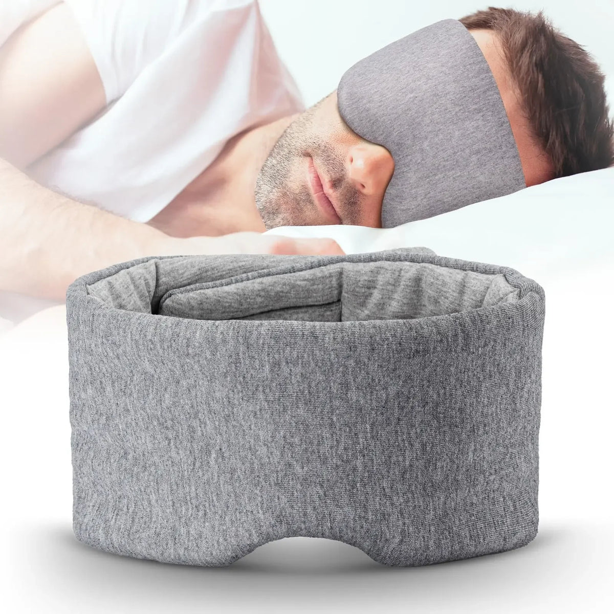 Un masque de sommeil en coton gris et confortable porté par une personne, avec un autre masque à proximité.