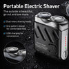 A portable electric shaver in black with dual rotary shaving heads and USB charging port shown on a dark surface.