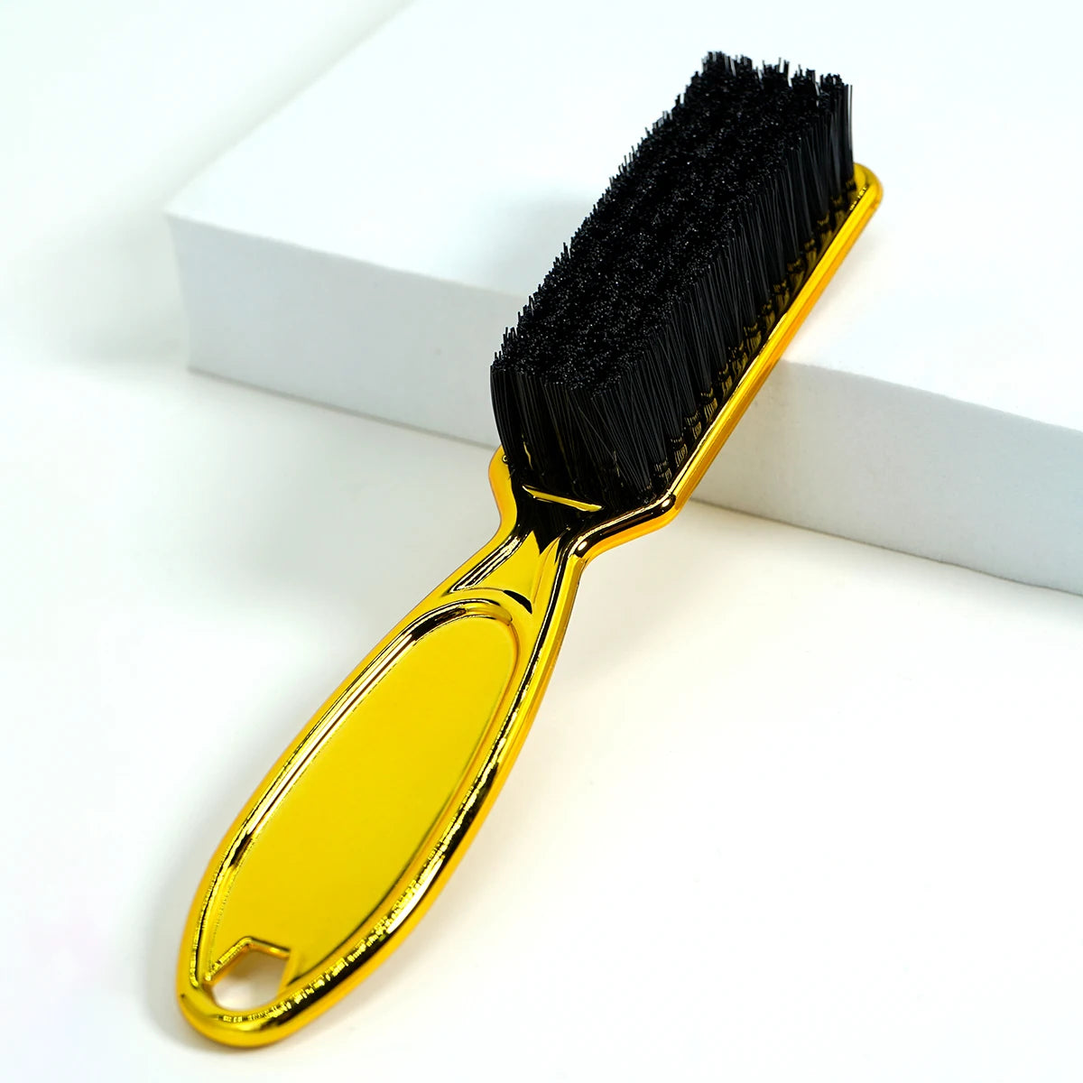A yellow professional duster brush with black bristles resting on a white surface.