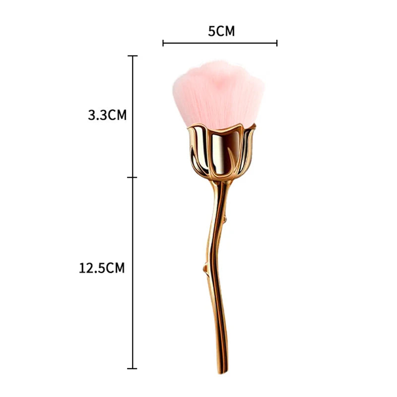 A gold-colored nail art dust brush with a pink fluffy head and a slender handle.