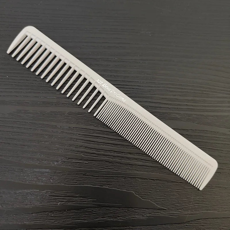 A white anti-static professional hair cutting comb lying diagonally on a dark wooden surface.