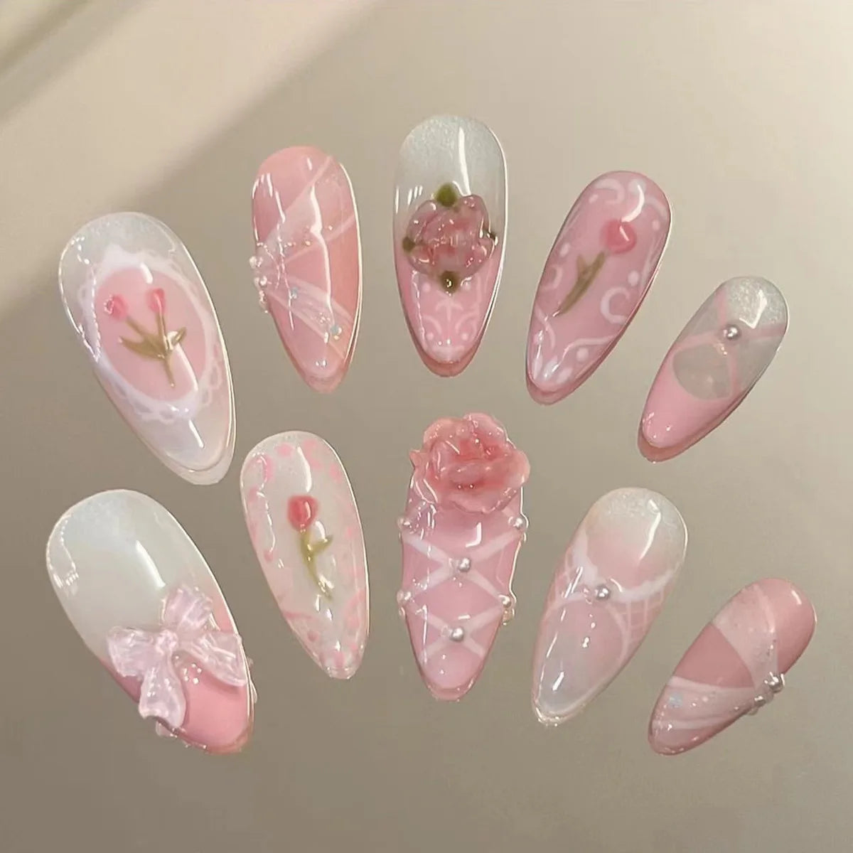 A collection of 24 pink heart pearl press-on fake nails with floral accents displayed on a neutral background.