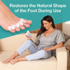 A woman is shown using silicone toe separators on her feet while relaxing on a couch.