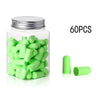 A clear jar filled with green memory foam earplugs and several loose green earplugs.