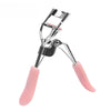 A silver makeup eyelash curler with pink silicone pads shown from the side.