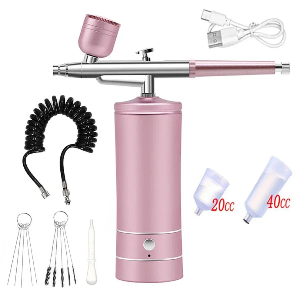 A pink portable airbrush kit featuring a metal airbrush, tubing, and various sizes of paint bottles for nail art and craft pa