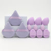 A set of twelve purple and pink makeup sponges arranged in a box.