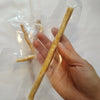 Eine Hand hält eine natürliche Miswak-Zahnbürste in einer durchsichtigen Plastiktüte.