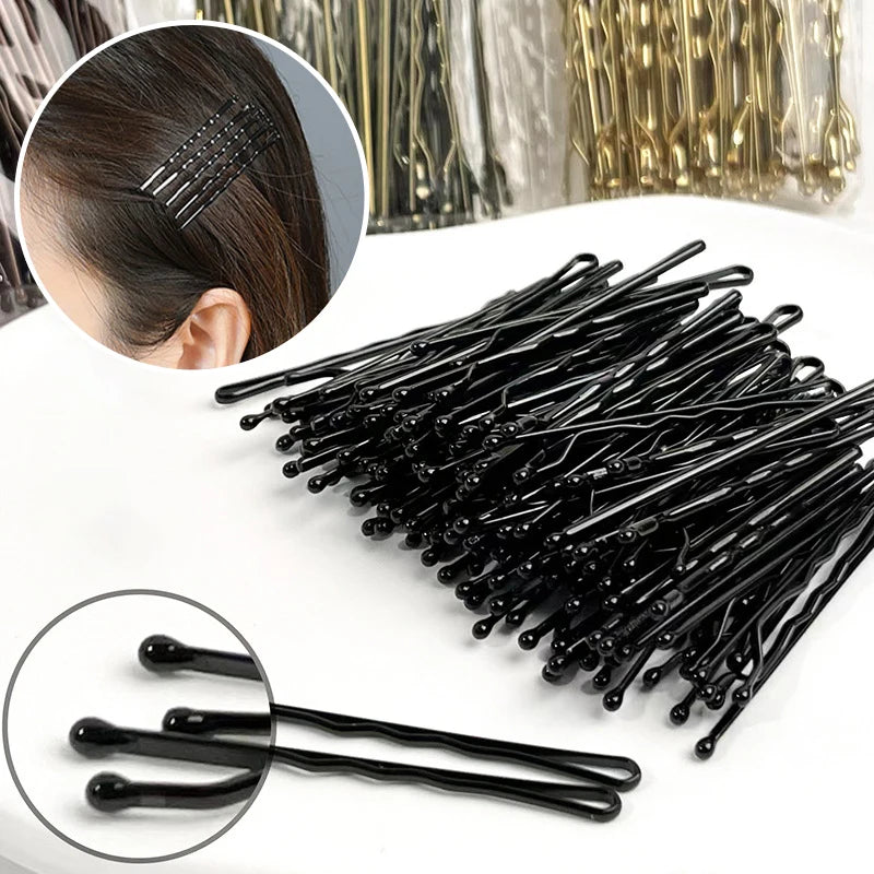 A collection of black metal U-shaped hair pins for styling, shown with a close-up of a single pin.