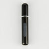 A sleek, black portable refillable perfume bottle with a silver band and a translucent inner section.