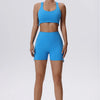 Modelo vistiendo un conjunto deportivo de yoga y gimnasio azul brillante, transpirable y de secado rápido, con top deportivo 